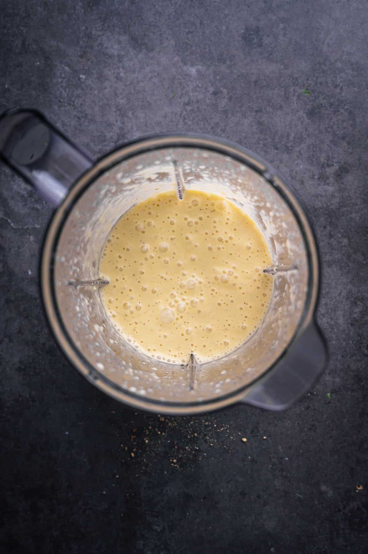 Ingredients for sweet onion and citrus dressing in a blender, blended up.
