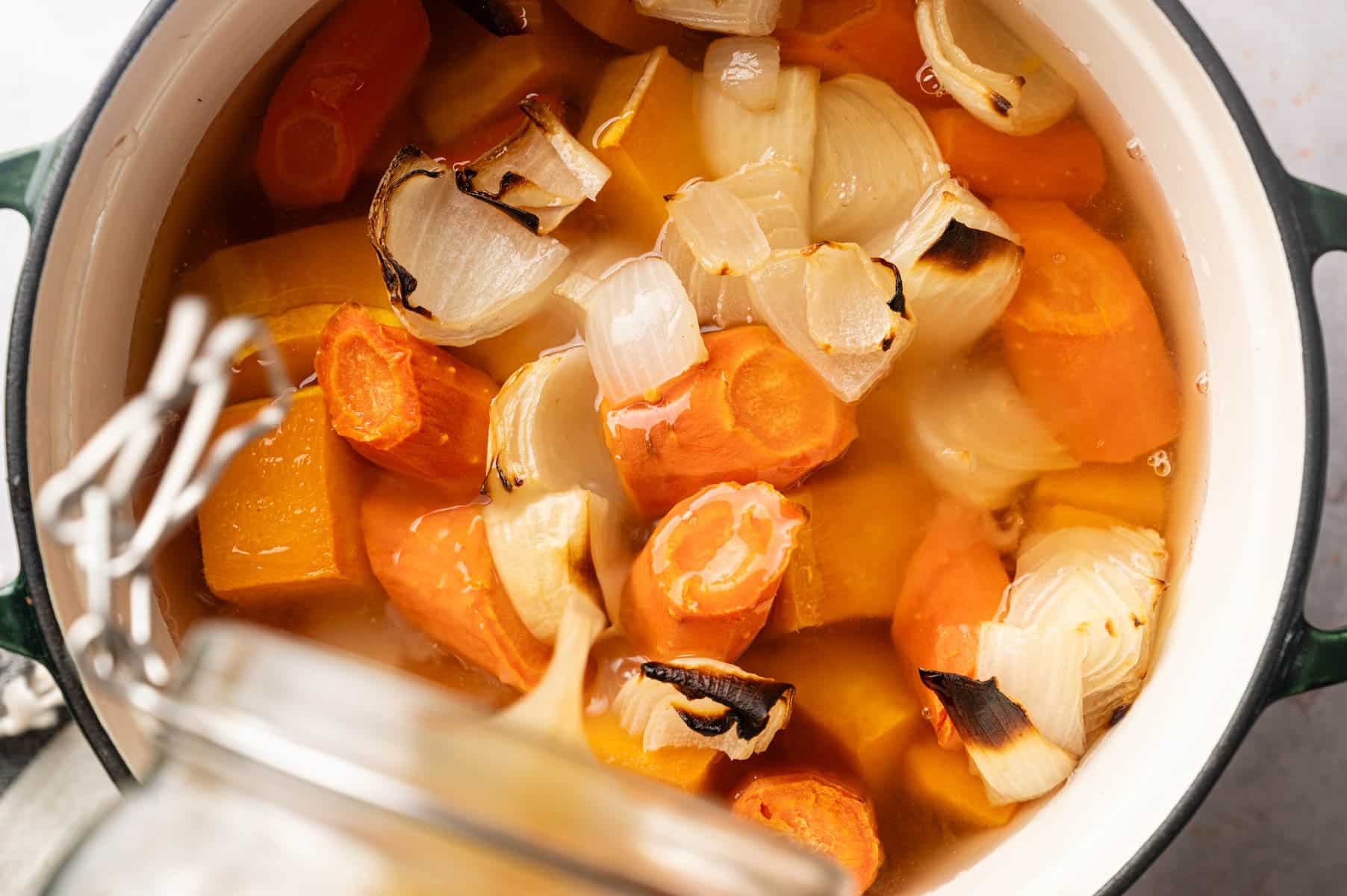 Veggie broth, herbs, salt, and pepper added to Dutch oven to simmer.