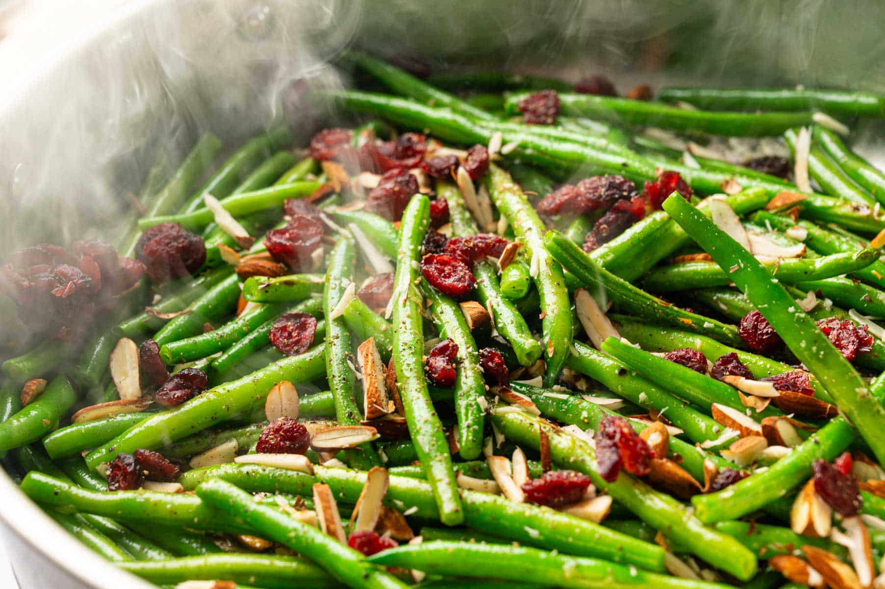 Close up of green beans in a pan with steam coming off of them.