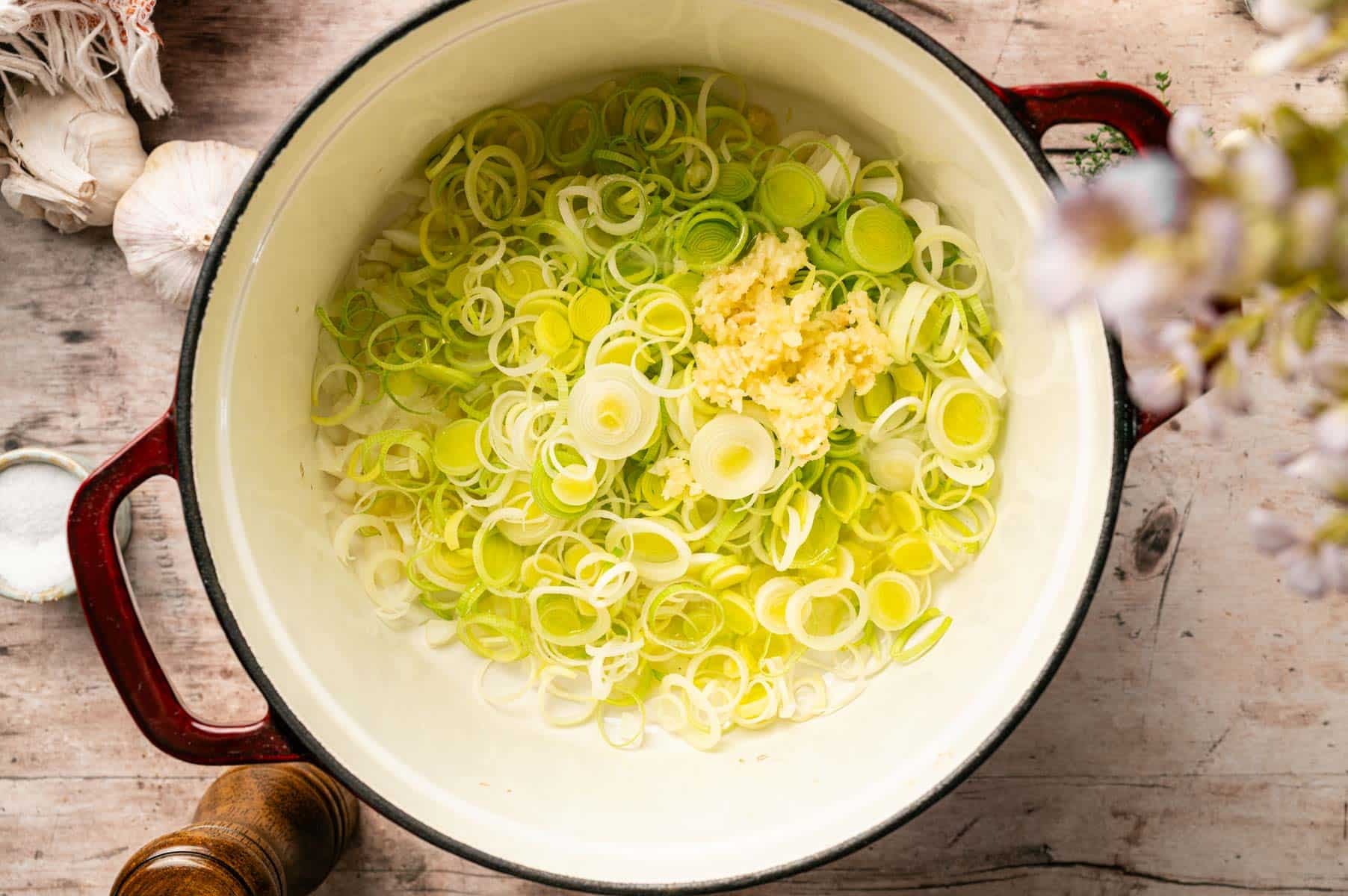 Chopped onion and leeks sautéing in a Dutch oven.